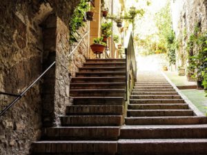 Zwei verschiedene Treppen nebeneinander. Eine Treppe ist steiler als die andere. Symbol für unterschiedliche Wege zur Veränderung.